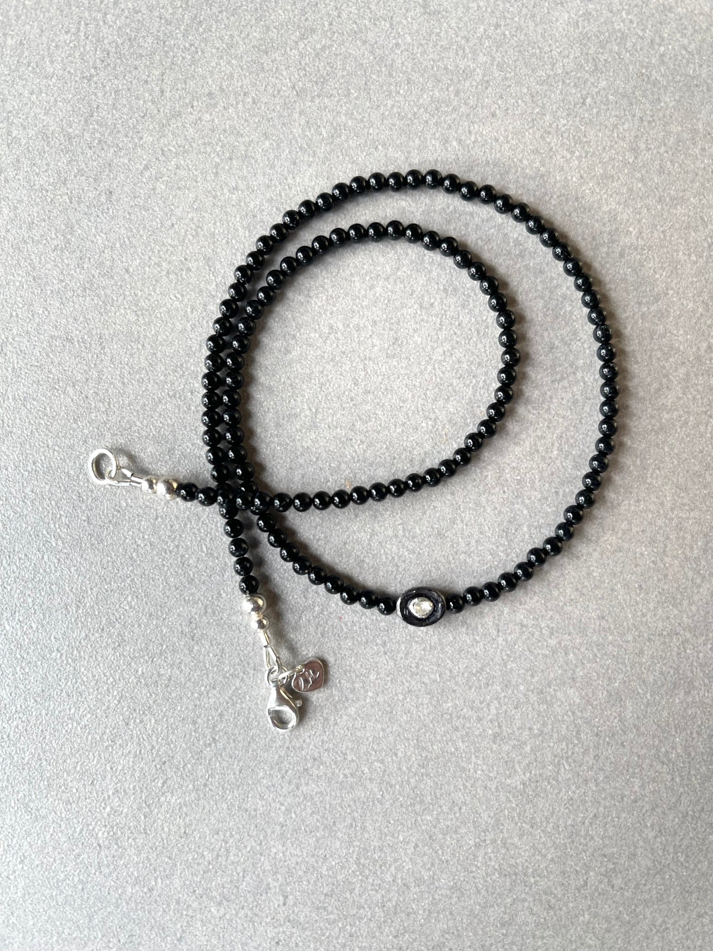 Necklace with an oxidized sterling silver pendant inset with a polki diamond
